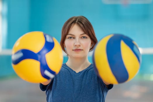 Old and new volleyballs in hands of a girl