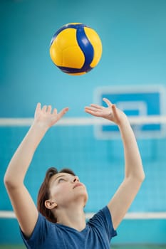 Photo in action of a girl training to pass and set the volleyball
