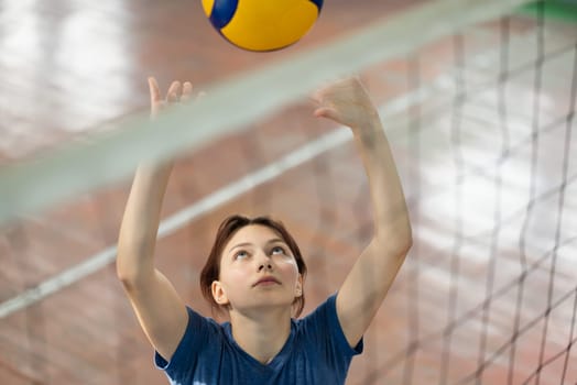 Young girl passing the ball received from the serving near the net