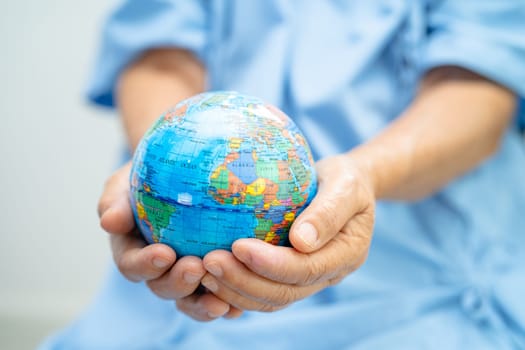 Bangkok, Thailand, January 1, 2023 Asian senior elderly old lady woman patient holding globe in hand on bed in nursing hospital