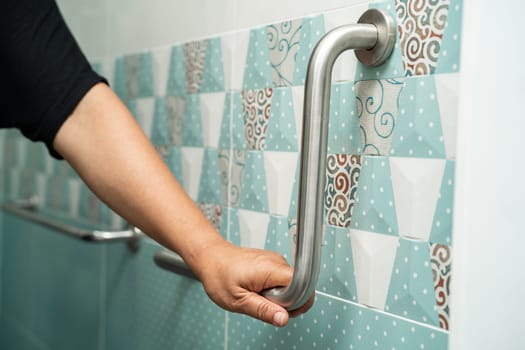 Asian elderly woman use bathroom handle security in toilet, healthy strong medical concept.