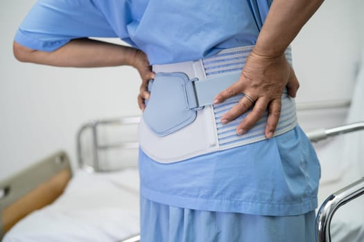 Asian lady patient use walker in hospital to support walking.