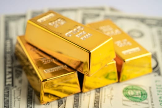 Gold bar on US dollar banknotes money, economy finance exchange trade investment concept.