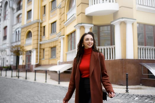 Smiling, stylish woman crossing the street in a hurry to work