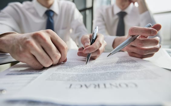 Close-up of male hands holding pen over document