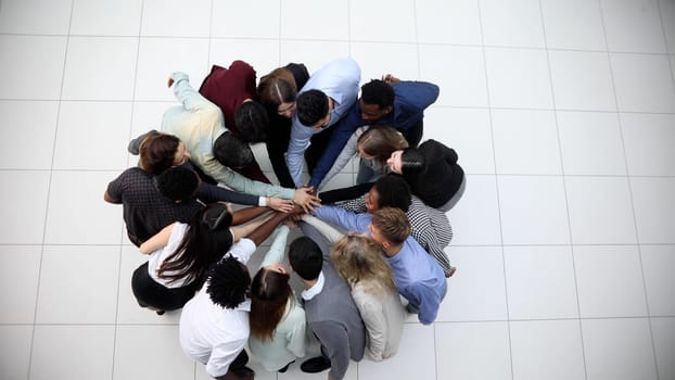 Friends with stack of hands showing unity and teamwork.
