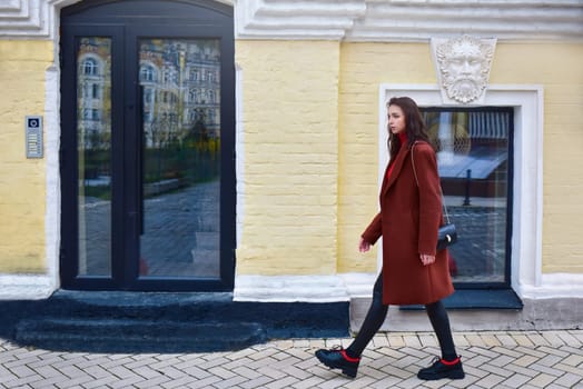 Woman with a concerned look on her face walks in a hurry down the street.