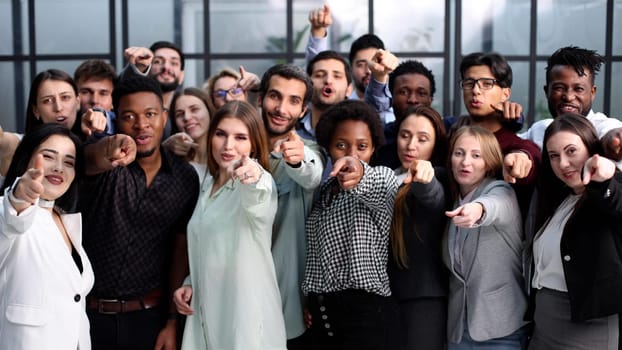 group of happy young people pointing at you