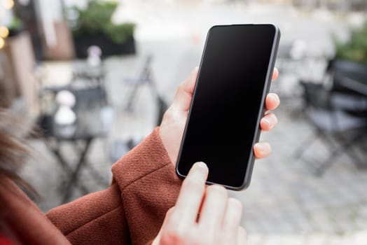 Cropped image of woman's hand holding smart phone with blank copy space screen for your text message or promotional content