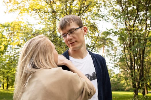 Couple In Park. Back View Of Woman Leaning To Man's Shoulder, Looking At One Another. Relationship, Togetherness. Enjoying Time Together. Feelings. Vertical Plane Summer Time. High quality photo