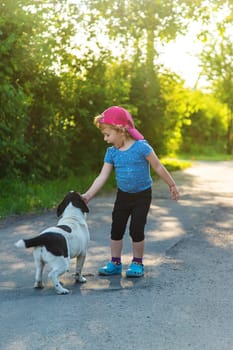 A child plays with a small dog in the park. Selective focus. Nature.