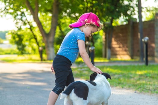 A child plays with a small dog in the park. Selective focus. Nature.