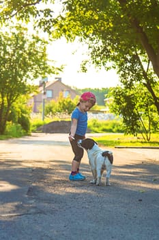 A child plays with a small dog in the park. Selective focus. Nature.