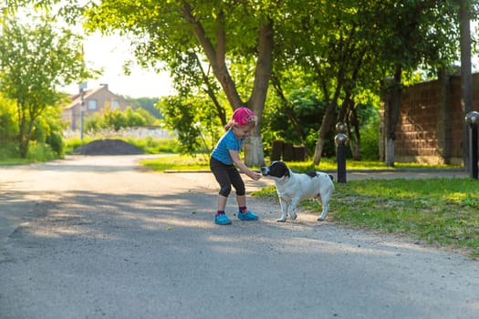 A child plays with a small dog in the park. Selective focus. Nature.