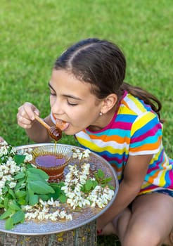 The child eats honey in the garden. Selective focus. Nature.