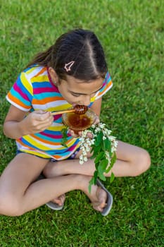 The child eats honey in the garden. Selective focus. Nature.