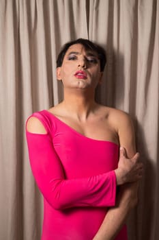 Homosexual in a pink female dress. A man in make-up