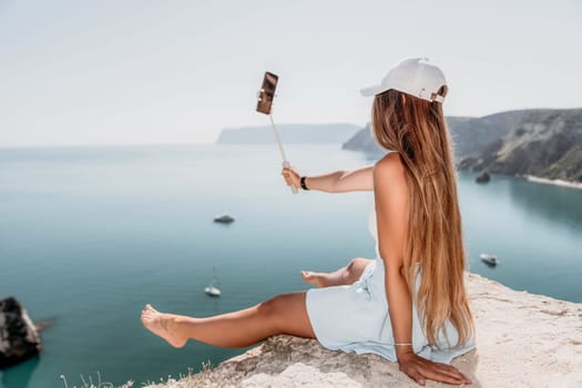 Digital nomad, Business woman working on laptop by the sea. Pretty lady typing on computer by the sea at sunset, makes a business transaction online from a distance. Freelance remote work on vacation