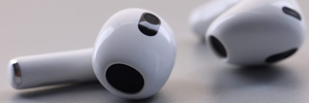 White headphones wireless headphones, on gray background. In-ear headphones wireless concept