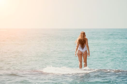 Woman sea yoga. Back view of free calm happy satisfied woman with long hair standing on top rock with yoga position against of sky by the sea. Healthy lifestyle outdoors in nature, fitness concept.