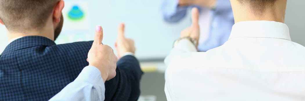 Team of business people hold thumbs up and recommend successful project. Partners present new project ideas successful business plan at the meeting.