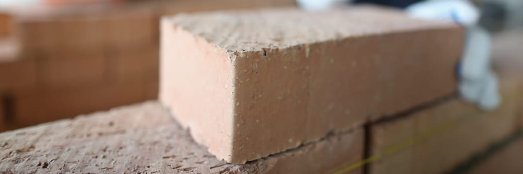 Closeup of industrial bricklayer laying bricks at construction site. Building brick walls concept