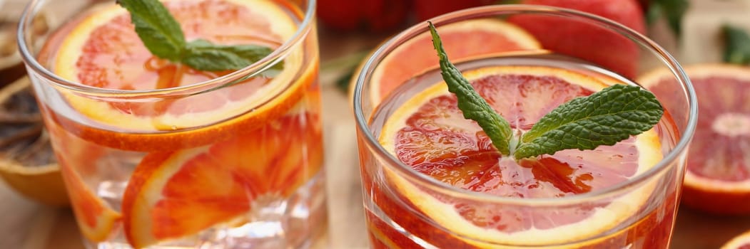 Water infused with citrus and mint leaves. Summer cold drink with ice with orange and strawberry