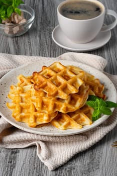 Belgian waffles and coffee on a gray background.