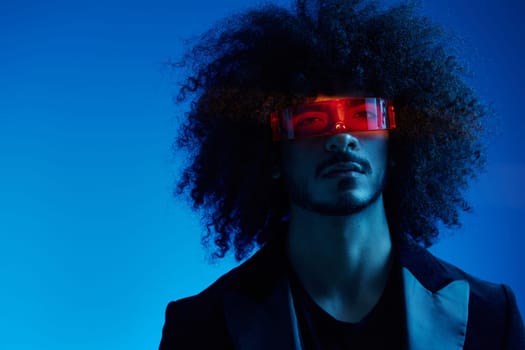 Fashion portrait of a man with curly hair on a blue background wearing red sunglasses, multinational, colored light, trendy, modern concept. High quality photo