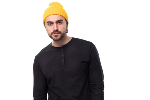 young well-groomed stylish brunette European brutal man in a black sweatshirt on a white background with copy space.