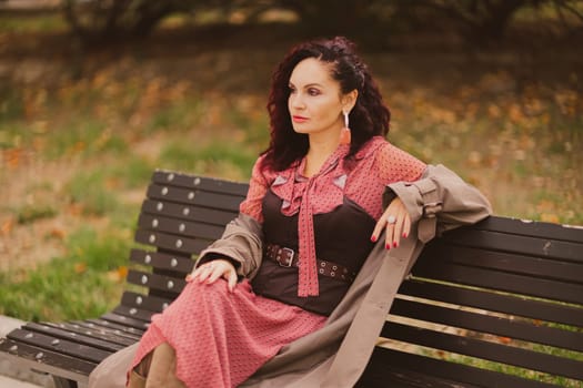 A woman walks outdoors in autumn, enjoys the autumn weather