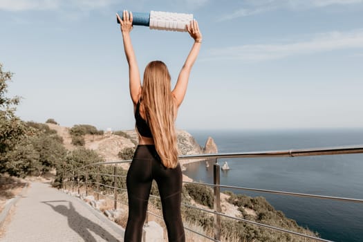 Fitness woman sea. Outdoor workout on yoga mat in park near to ocean beach. Female fitness pilates yoga routine concept. Healthy lifestyle. Happy fit woman exercising with rubber band in park.