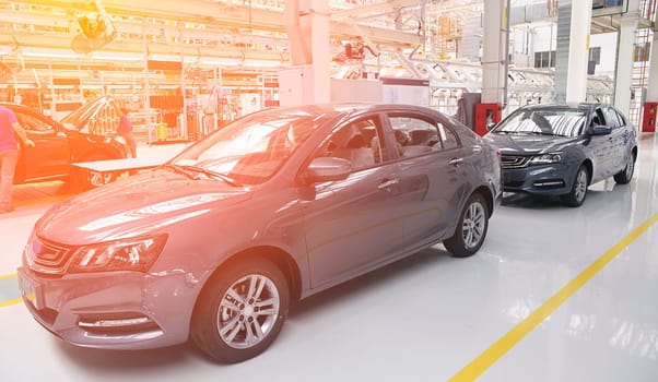 Photo of automobile production line. Modern car assembly plant. Modern and high-tech automotive industry. Conveyor of auto bodies