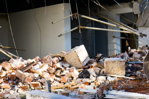 Background of process of demolition of a building. Excavator breaking old house.