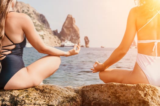 Woman sea yoga. Back view of free calm happy satisfied woman with long hair standing on top rock with yoga position against of sky by the sea. Healthy lifestyle outdoors in nature, fitness concept.