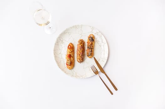 Eclairs with various fillings on a gray plate isolated