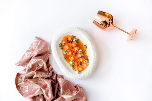 Exquisite serving of salmon ceviche with mango gel on a white plate isolated