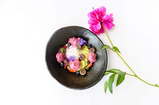 Dessert with ice cream and avocado, decorated with flowers on a white background
