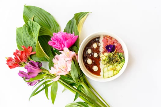 Tuna poke in white dishes decorated with bright flowers on a white background