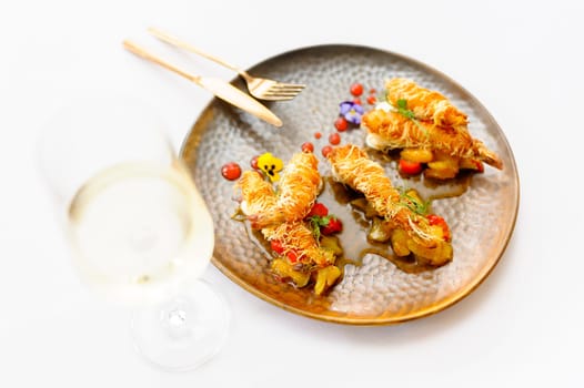 Exquisite serving of shrimps in batter on a brown plate on a white background