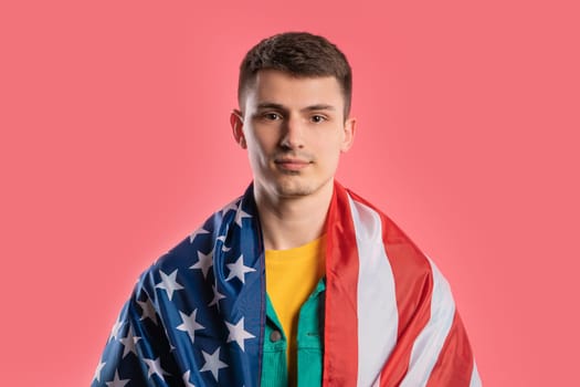 Happy man with national USA flag on studio pink background. American patriot, 4th of July - Independence day celebration, election, America, labor. US banner. High quality