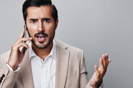 man studio beige guy call hold gray mobile suit phone angry smartphone connection cellphone confident adult success smile background phone business portrait