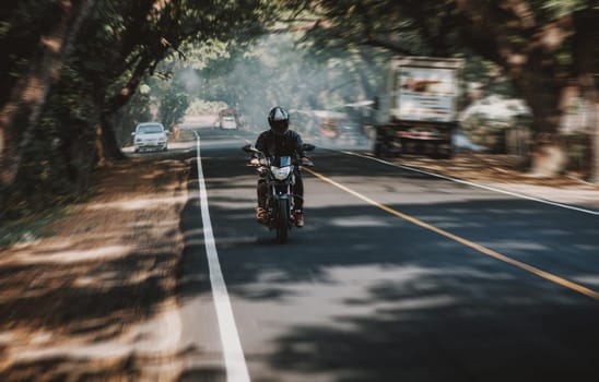 Motorcycle driver at full speed on the highway. Motorcyclist driving at high speed on the street