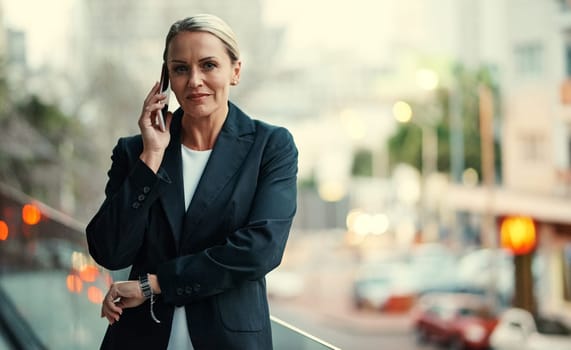 Communication is a key part of any business. Cropped portrait of an attractive mature businesswoman using her cellphone while standing on the balcony of her office