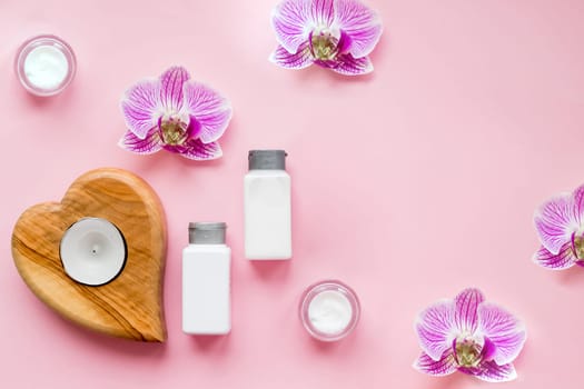 Spa beauty products on pink background. oil, cream, serum, perfume candles