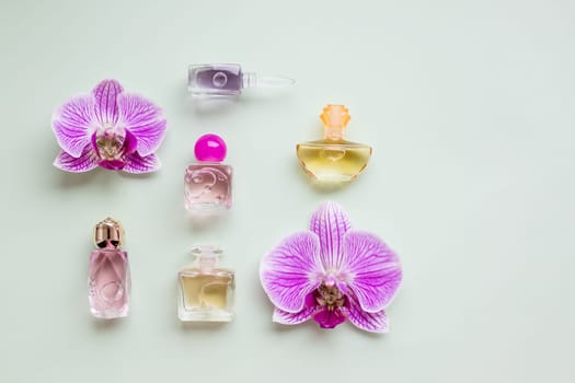 bottle of womens perfume and a delicate orchid flower