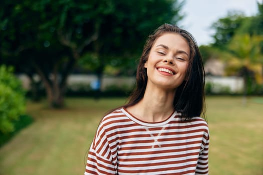 summer woman outdoor black hair wellness exercise lifestyle smile freedom beautiful female nature meadow carefree long t-shirt happiness portrait smiling park walk