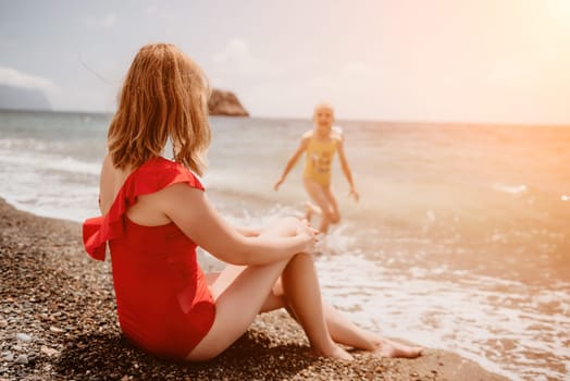 Happy loving family mother and daughter having fun together on the beach. Mum playing with her kid in holiday vacation next to the ocean - Family lifestyle and love concept.