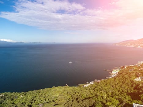 Sea landscape with rocky coastline on sunset time with cloudy sky. Yachts in the Sea on a background of rocky shores. The concept of perfect place for summer travel and rest.