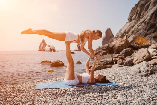 Woman sea yoga. Back view of free calm happy satisfied woman with long hair standing on top rock with yoga position against of sky by the sea. Healthy lifestyle outdoors in nature, fitness concept.